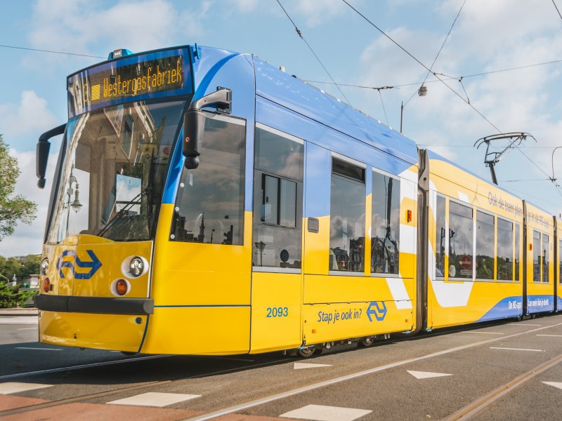 De speciale in NS-huisstijl bestickerde tram in Amsterdam bij de GVB. (Foto: NS / Kristel van Dijk)